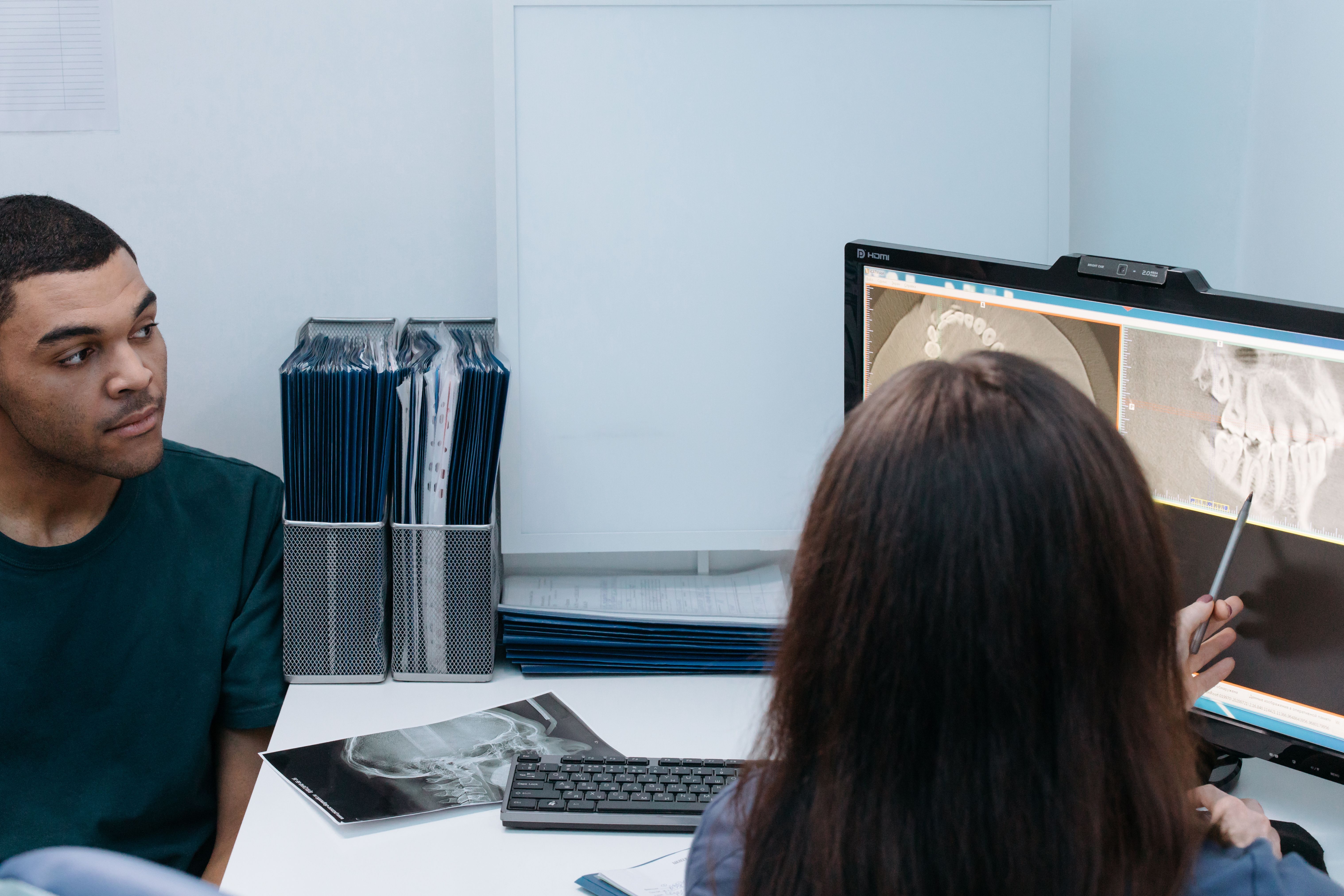 A dental professional explaining dental X-rays to a patient
