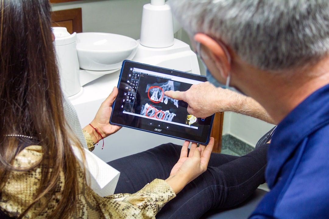 A dentist reviewing digital dental X-rays with a patient