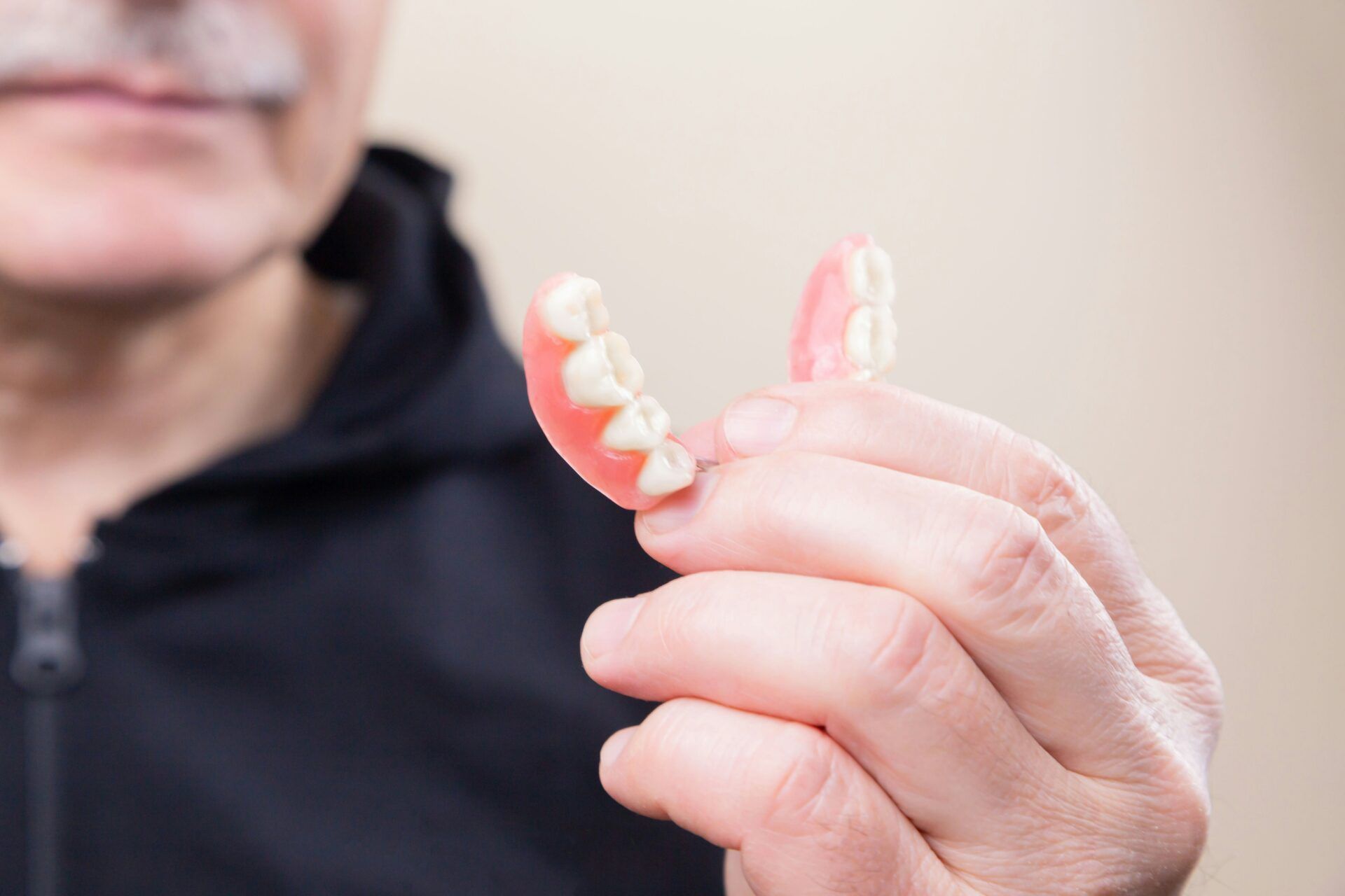 A person holding a removable partial denture