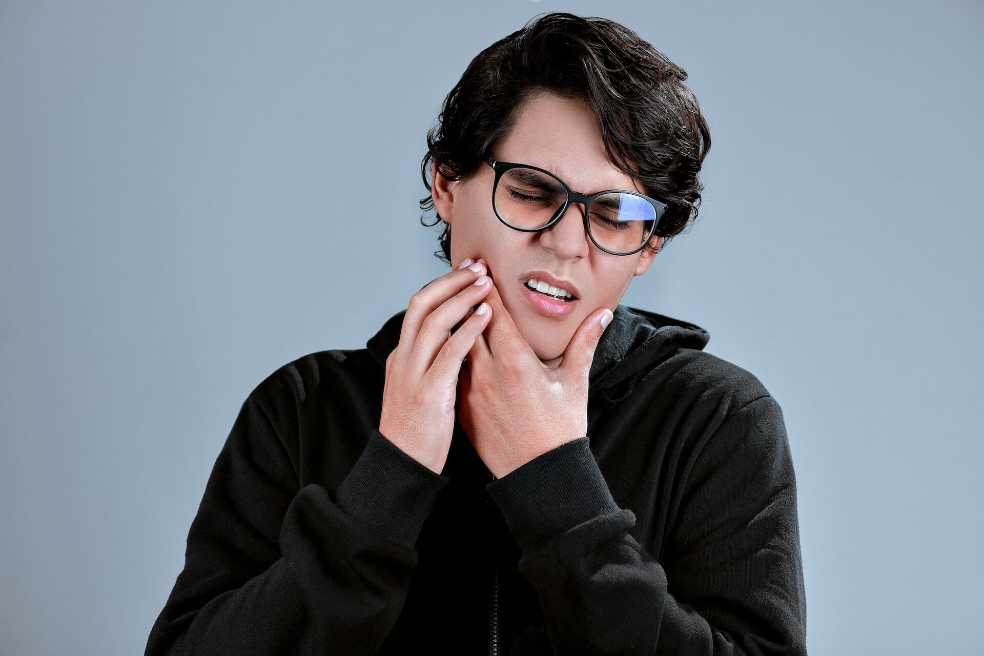 A person experiencing discomfort near the jaw joint
